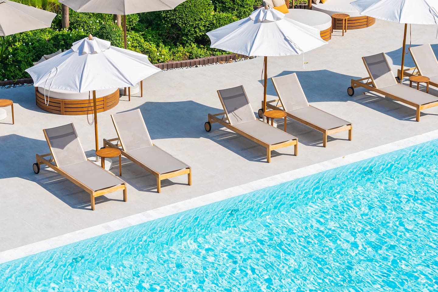 Poolside loungers and white umbrellas at Tea Tops Hideaway