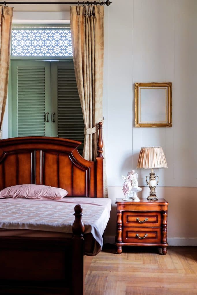 Superior room with a classic wooden bed and bedside table