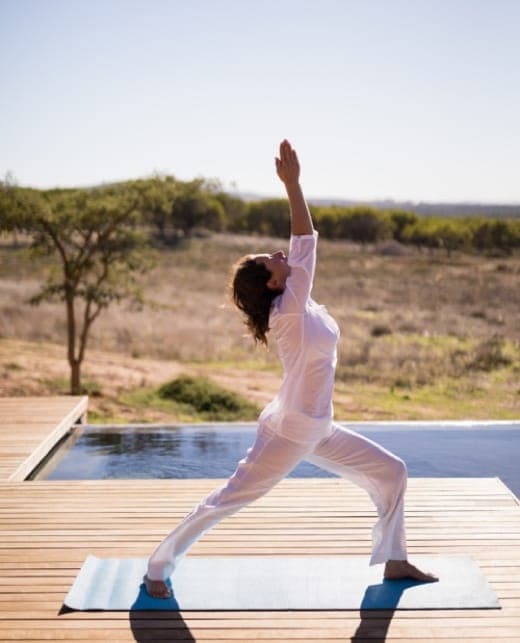 Guest practicing yoga beside a pool at Tea Tops Hideaway